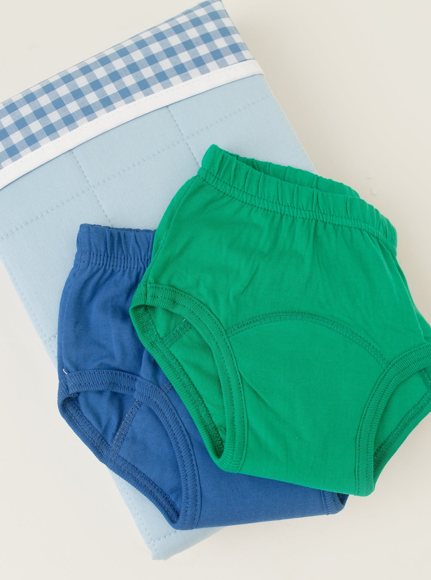 BLue and Green day training pants on folded blue brolly sheet