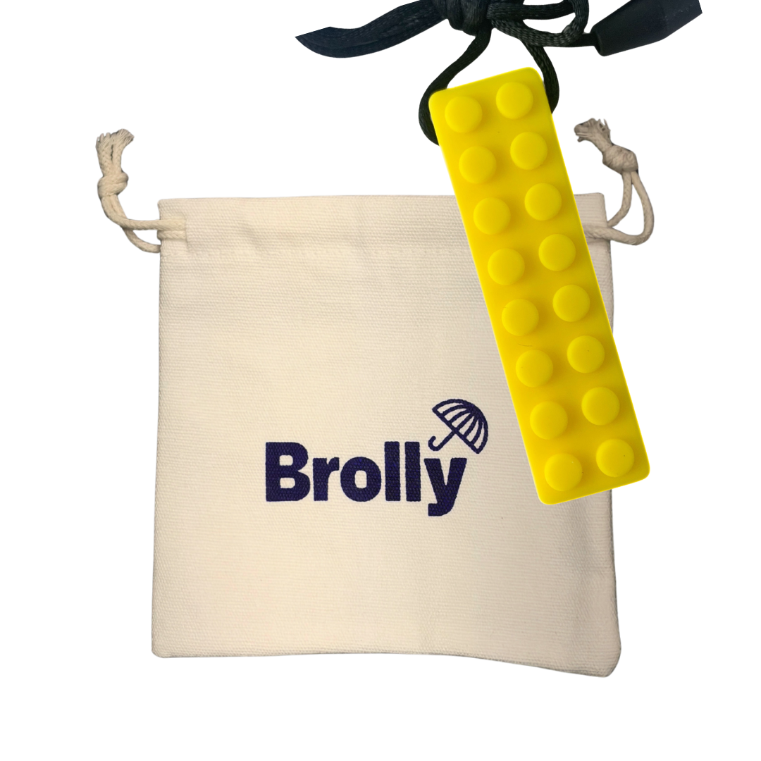 Beige drawstring pouch and brick-shaped Brolly Sheet Chew Necklace on a black cord against a white background - Yellow