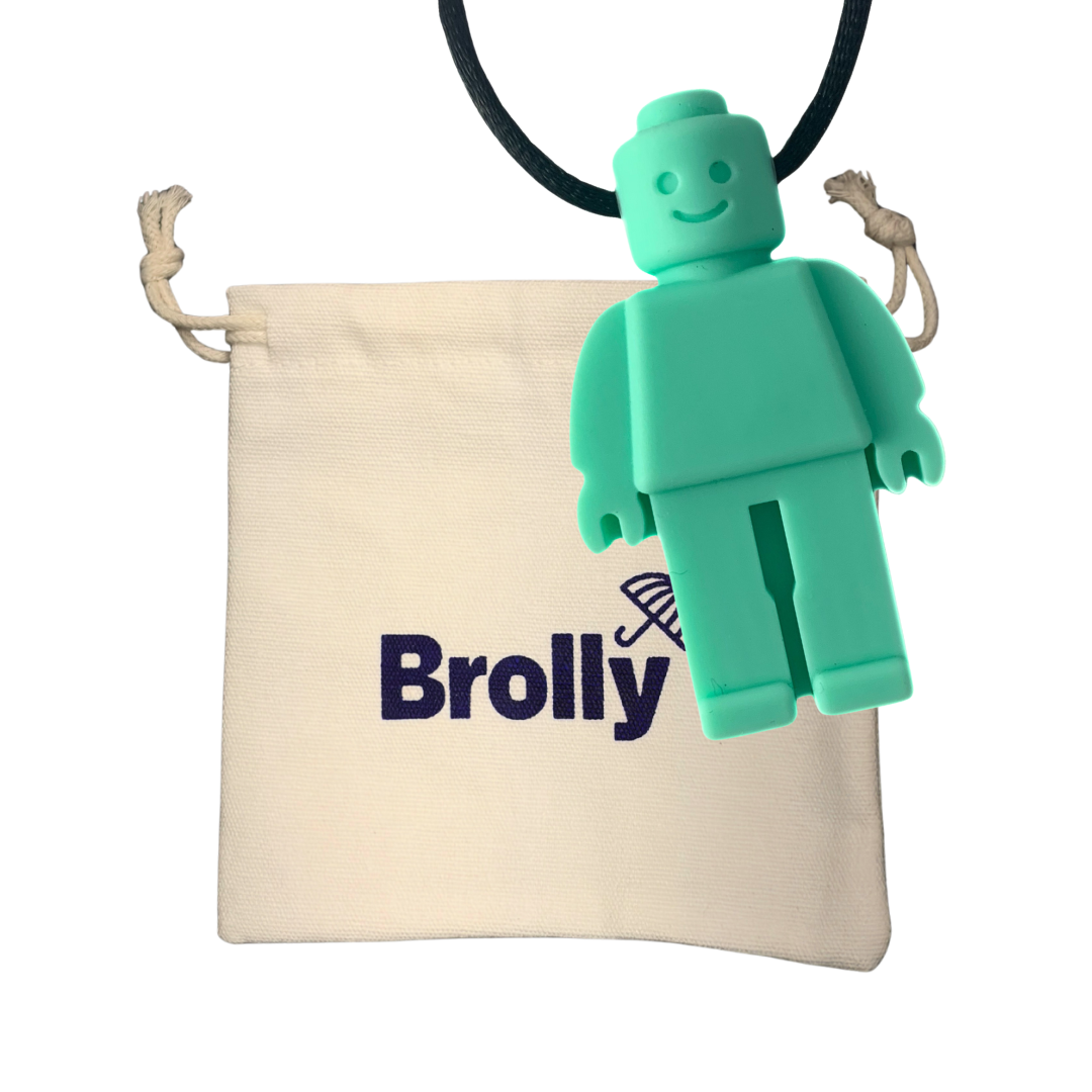 Beige drawstring pouch and robot-shaped Brolly Sheet Chew Necklace on a black cord against a white background - Mint