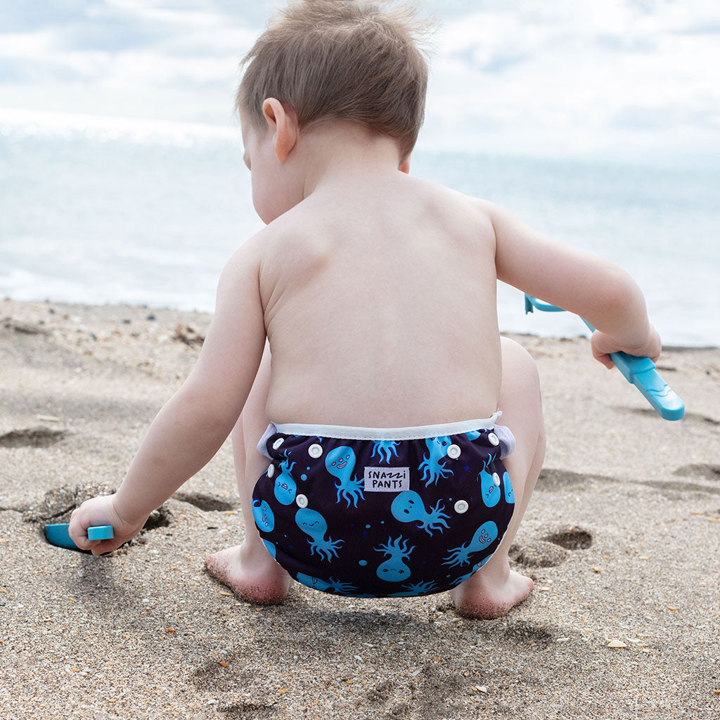 Child wearing a colorful nappy on a beach - Octopus
