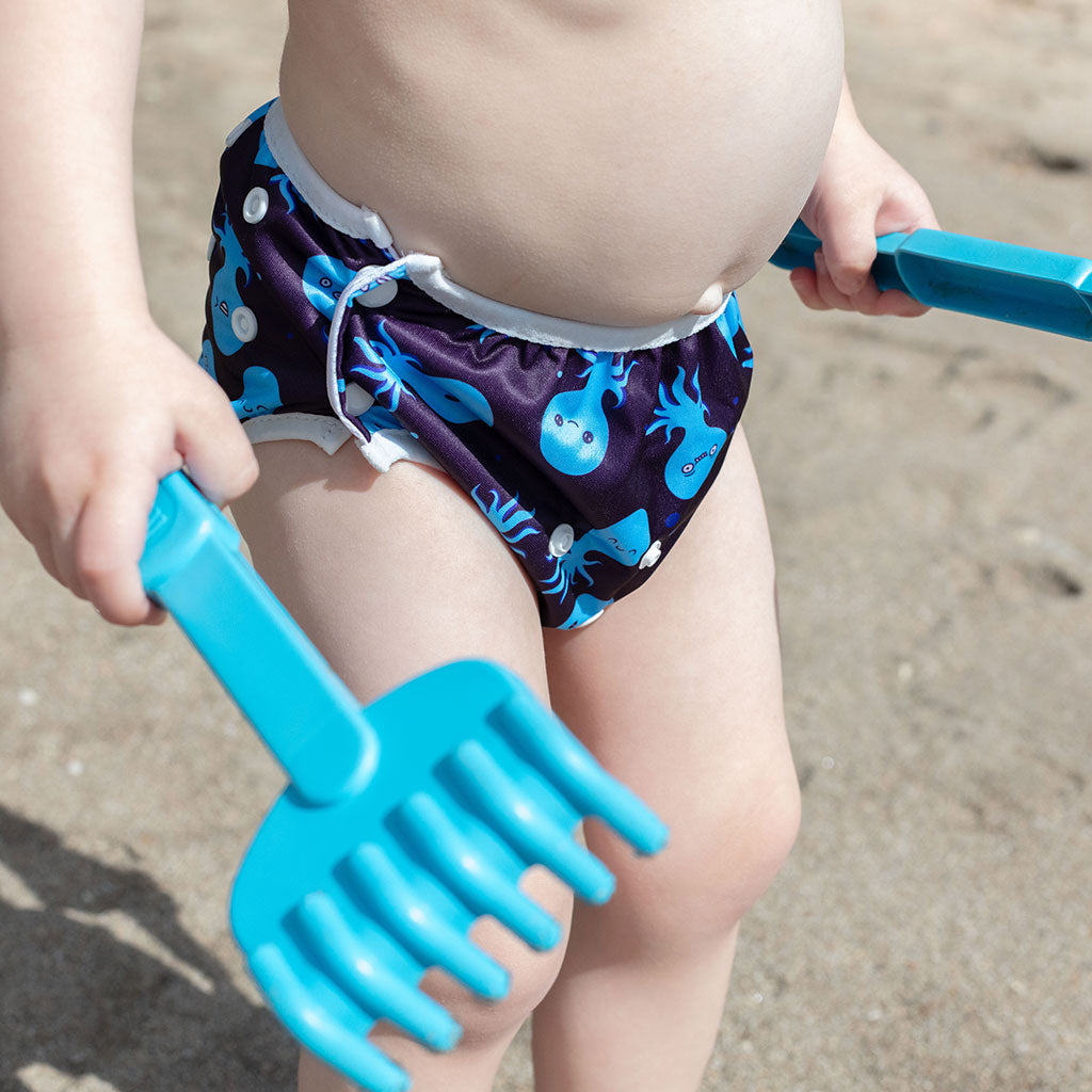 Child wearing a colorful nappy on a beach - Octopus