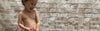 Child standing in front of brick wall