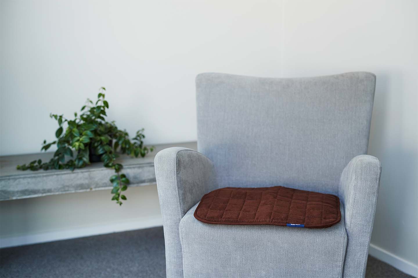 Grey chair with brown chair pad on it