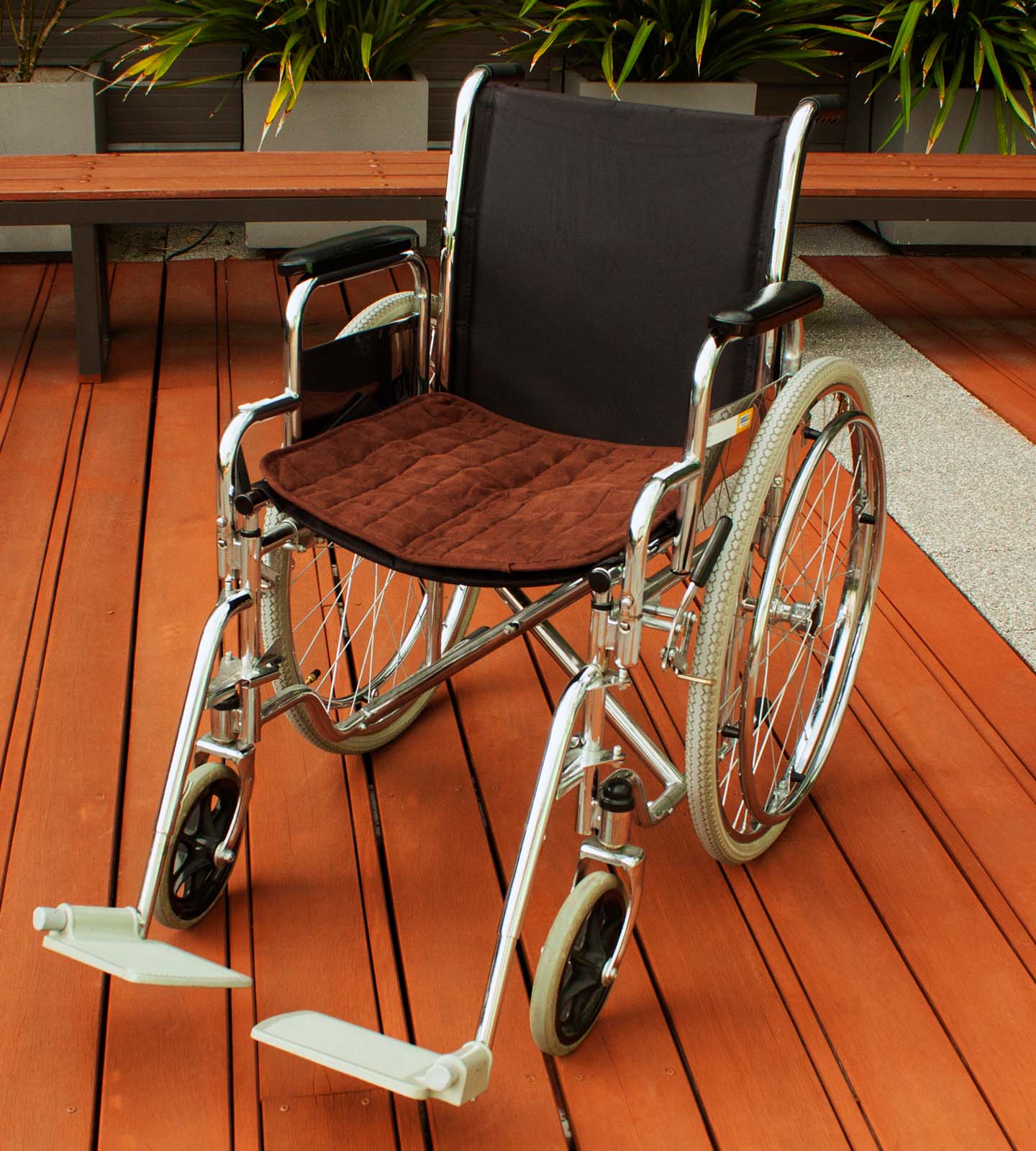 Wheel chair with Brown chair pad on it