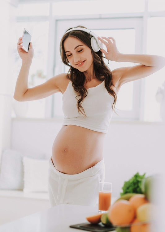 Pregnant Girl Wearing Headphones Holding PC Tablet