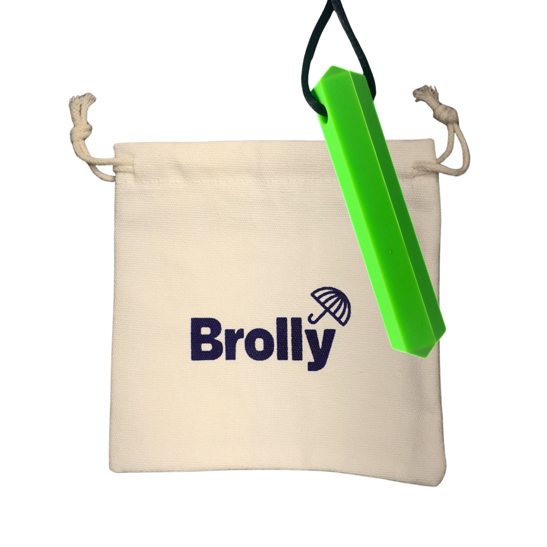 Beige drawstring pouch and hexagon-shaped Brolly Sheet Chew Necklace on a black cord against a white background - Green