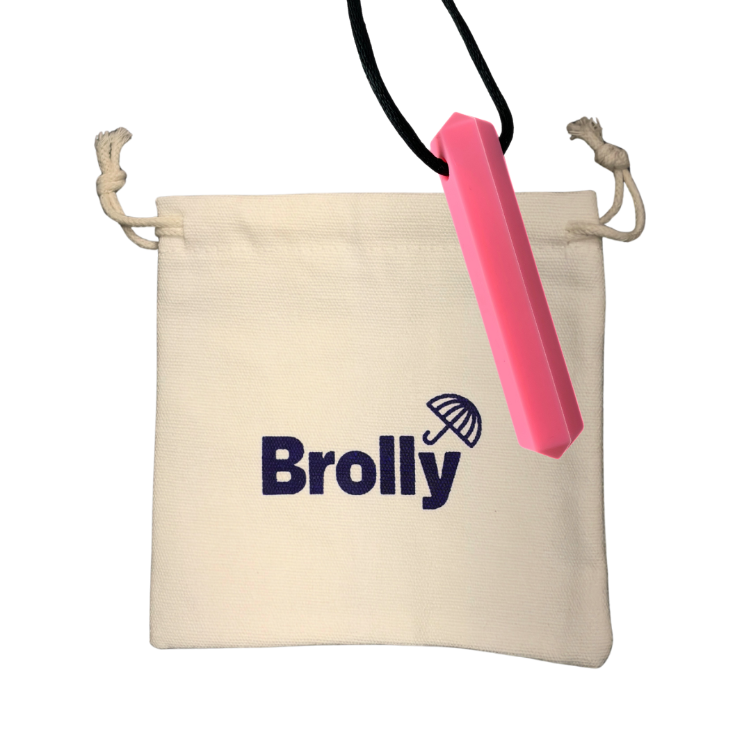 Beige drawstring pouch and hexagon-shaped Brolly Sheet Chew Necklace on a black cord against a white background - Pink