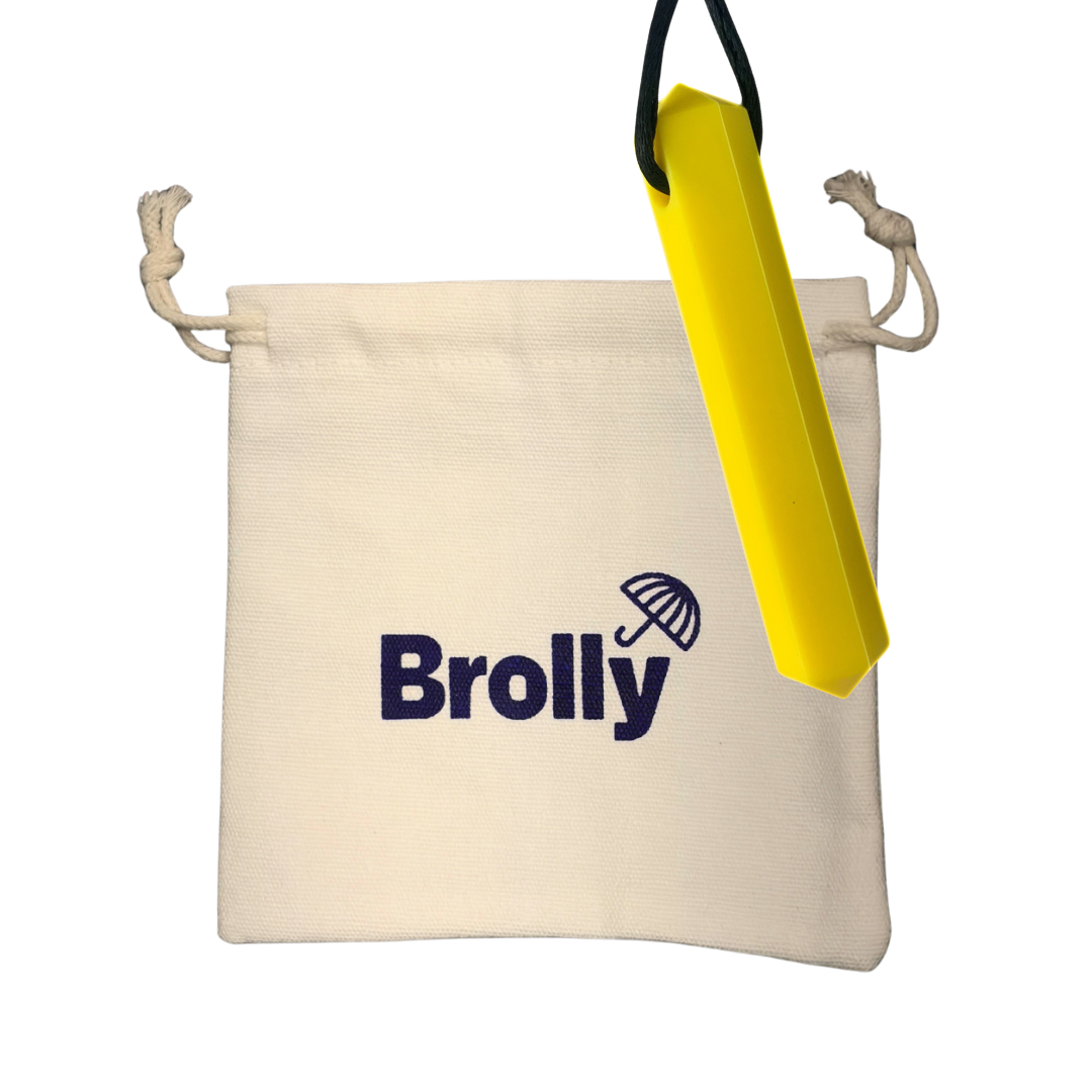 Beige drawstring pouch and Hexagon-shaped Brolly Sheet Chew Necklace on a black cord against a white background - Yellow