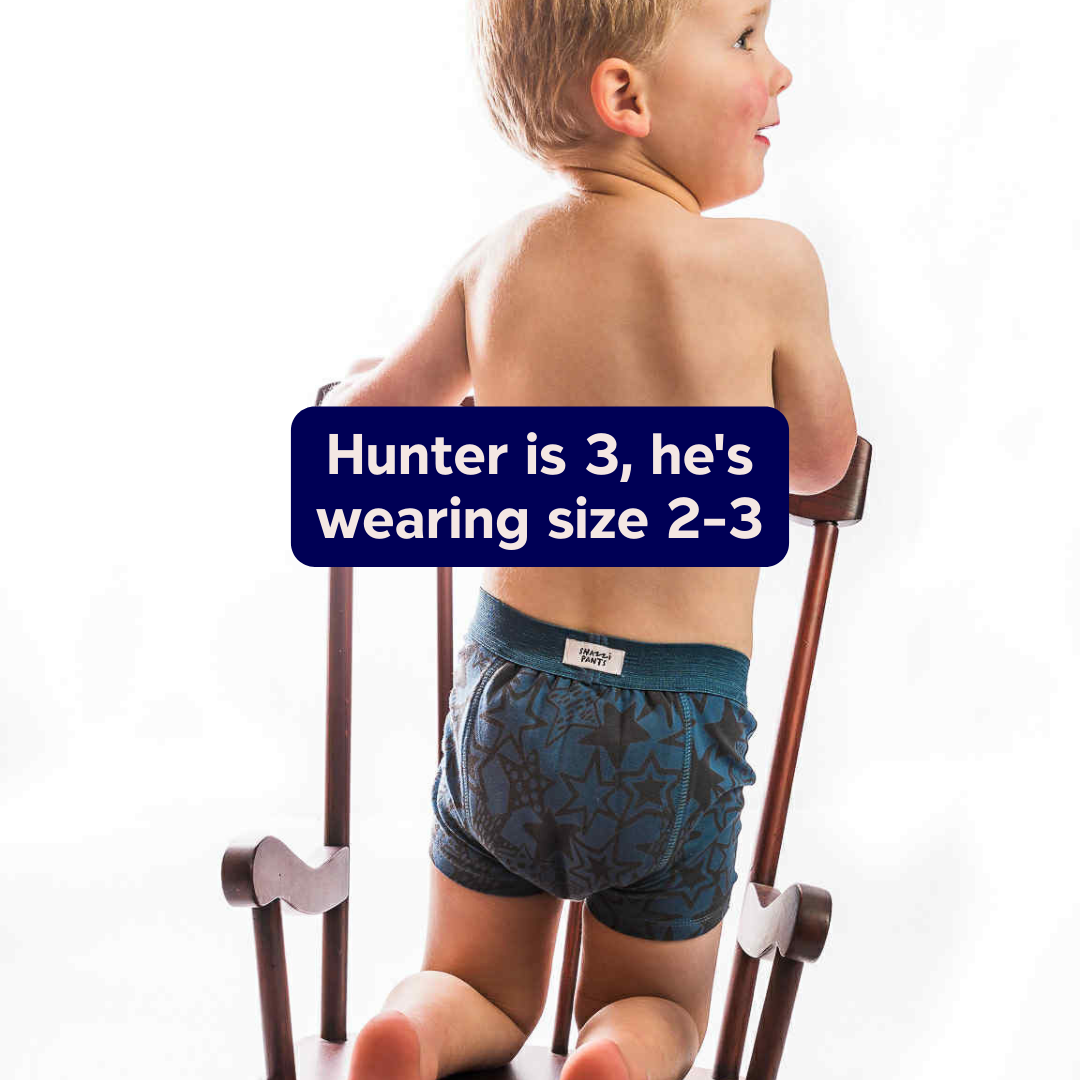 Child wearing a size 2-3 Snazzi Pants Night Trainer, sitting on a chair - Rock Star

