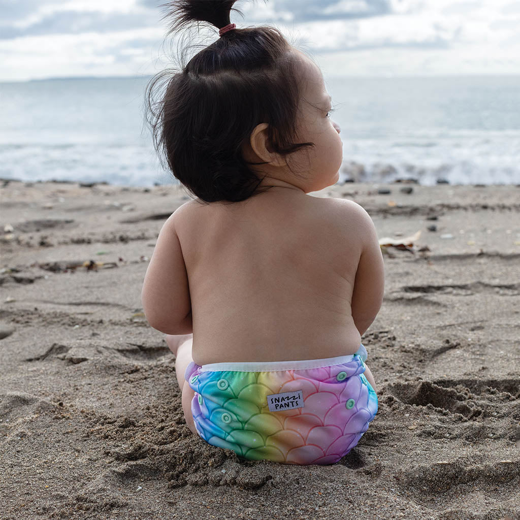 Child wearing a colorful nappy on a beach - Mermaid