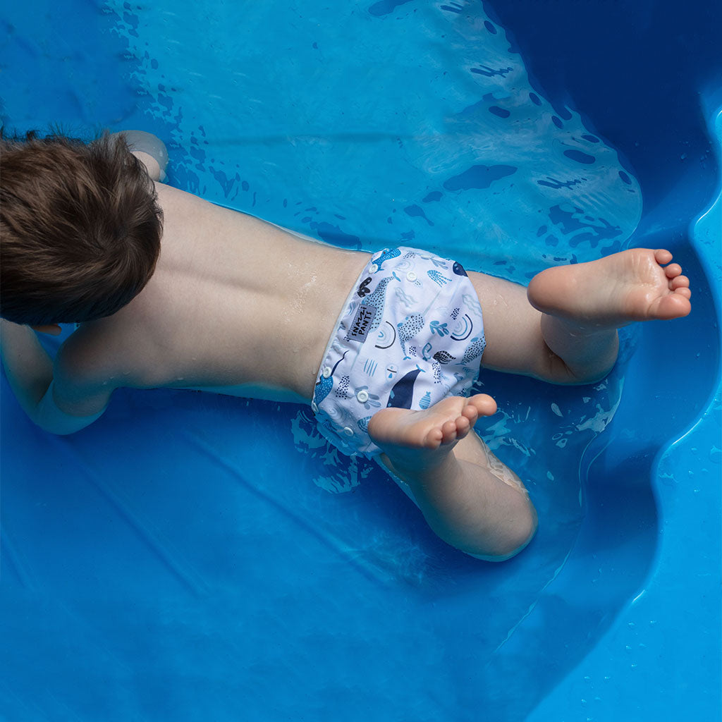 Child wearing a colorful nappy on a mini pool - Narwhales
