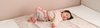Child lying on Dusty Rose Unicorn rolly SHeets (Bed Pad with Tuck in wings)