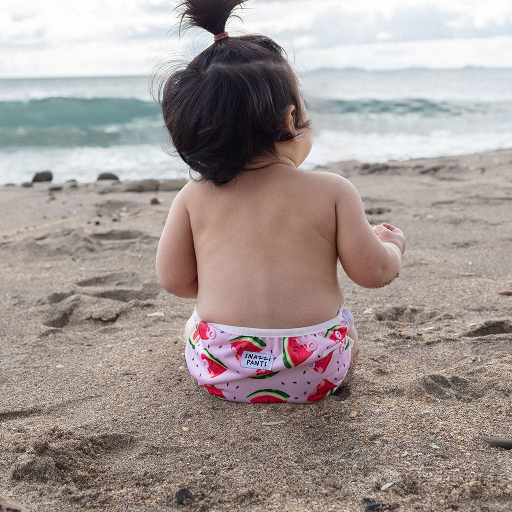 Child wearing a colorful nappy on a beach - Watermelon