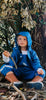 A young boy wearing our Brolly Wet Weather Gear Set in Denim playing under a tree in the outdoors