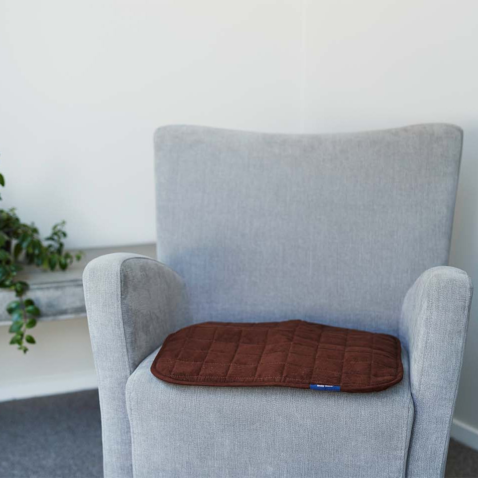 Grey chair with brown chair pad on it 
