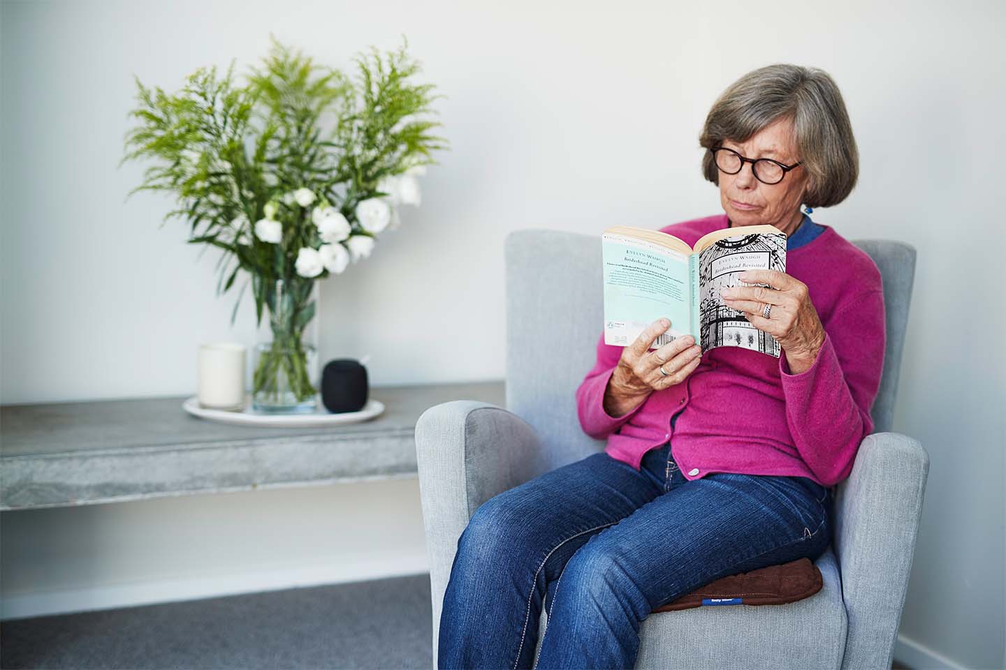 Lady reading a book sitting on a chair pad 