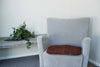 Grey chair with brown chair pad on it 