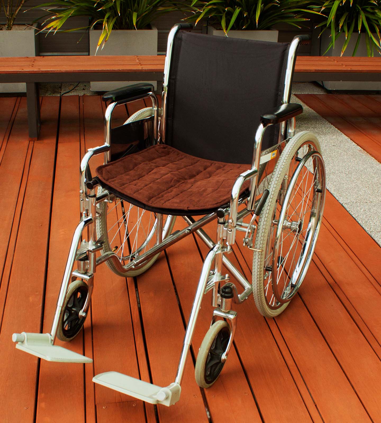 Wheel chair with Brown chair pad on it 