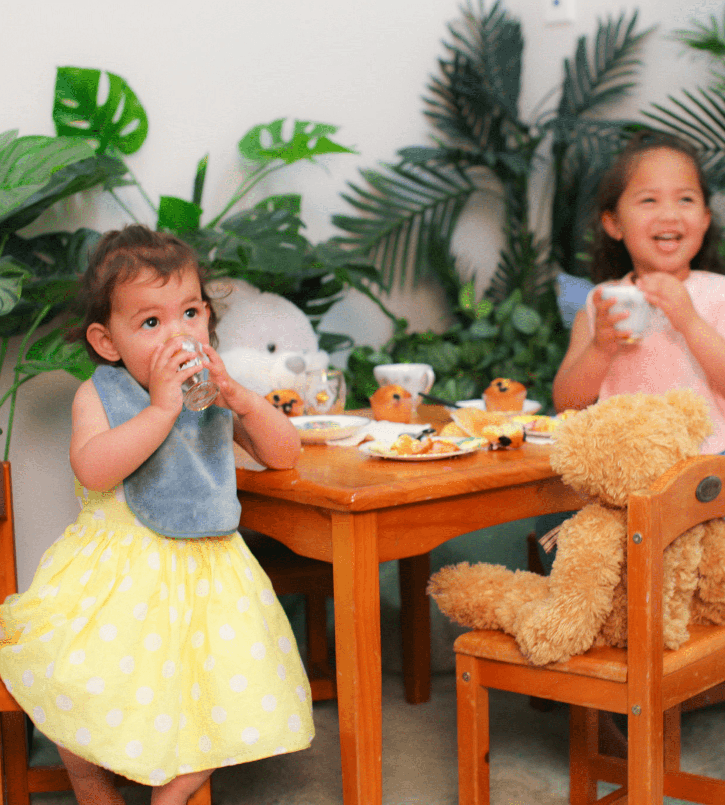 Toddler and Baby having a tea party in our Thyme Extra Absorbent Bib and our Pink Extra Absorbent Bib